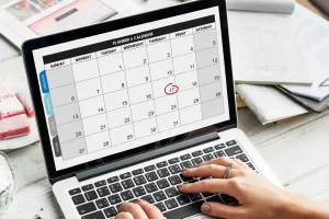woman working on laptop looking at calendar